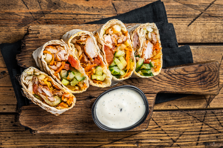 Chicken wrap roll, durum doner kebab with meat and vegetable salad. Wooden background. Top view