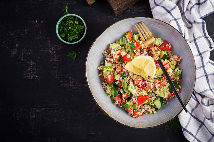 Tabbouleh salad. Traditional middle eastern or arab dish. Levantine vegetarian salad with parsley, mint, bulgur, tomato. Top view